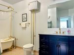 A clawfoot tub and bold navy vanity add timeless flair.